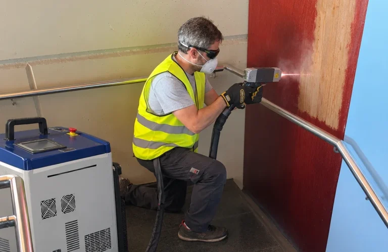 Texto alternativo (Alt Text): Operador realizando decapado de pintura con láser en pared y superficies de un edificio en Cataluña Laserklin